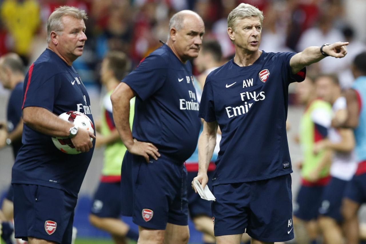 'Arsenal\'s manager Arsene Wenger (R) talks with coaches during a training session ahead of a soccer friendly match against Urawa Reds in Saitama, north of Tokyo July 25, 2013. Arsenal is on a pre-sea