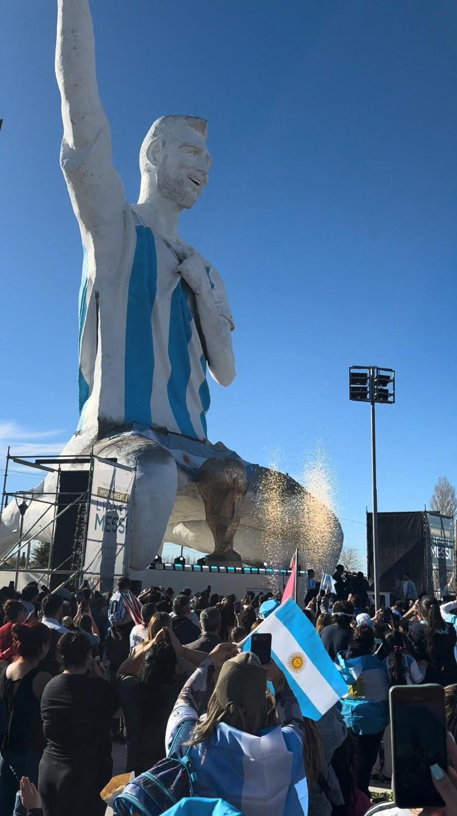 People are gathered near a statue of Lionel Messi in Neuquen Province