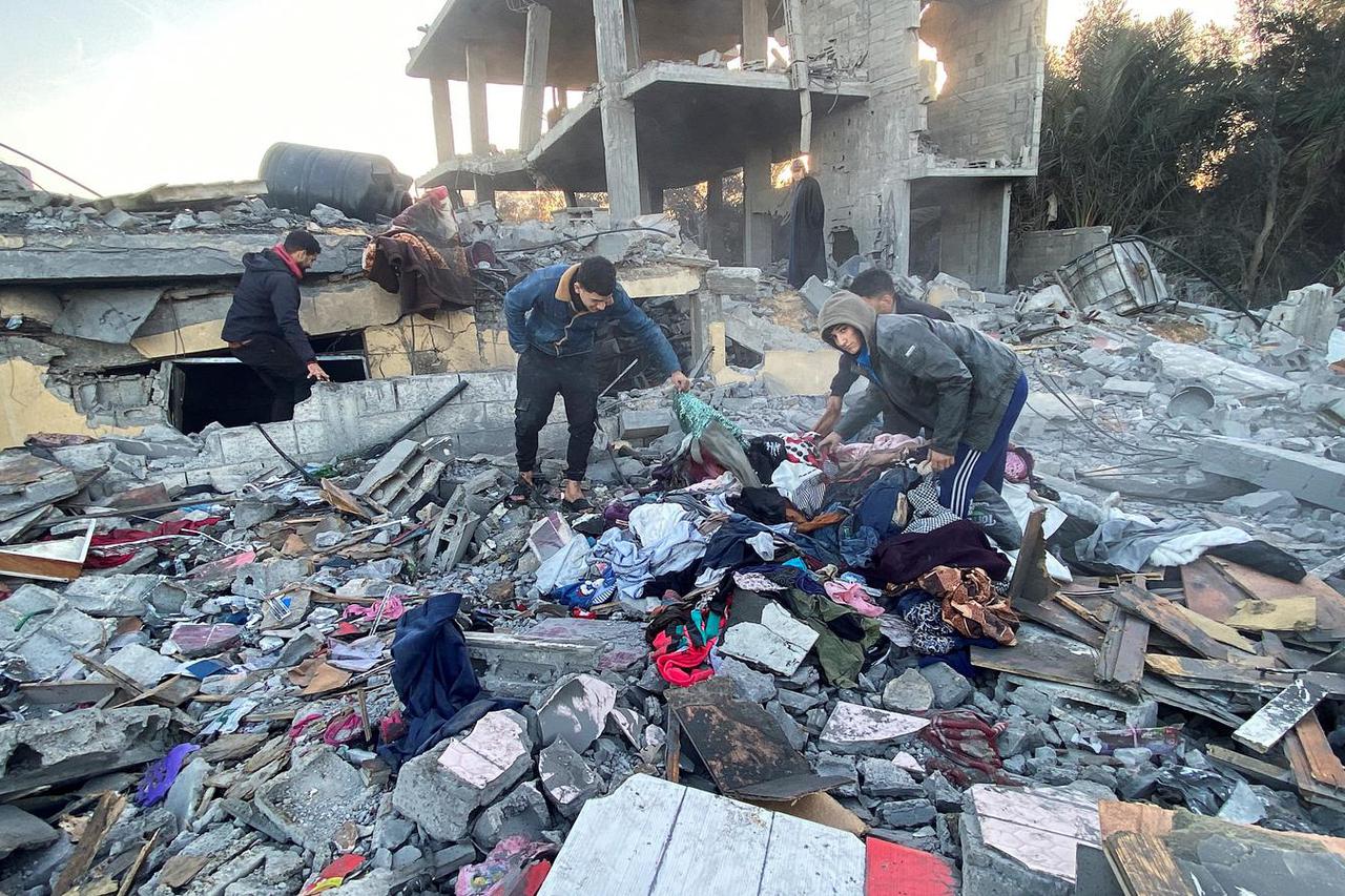 Palestinians inspect the site of an Israeli strike on a house, in Khan Younis