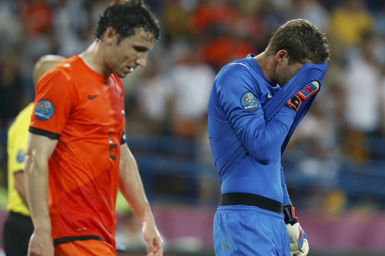 'Netherlands\' goalkeeper Maarten Stekelenburg (R) and Mark van Bommel react during their Group B Euro 2012 soccer match against Germany at the Metalist stadium in Kharkiv June 13, 2012.         REUTE