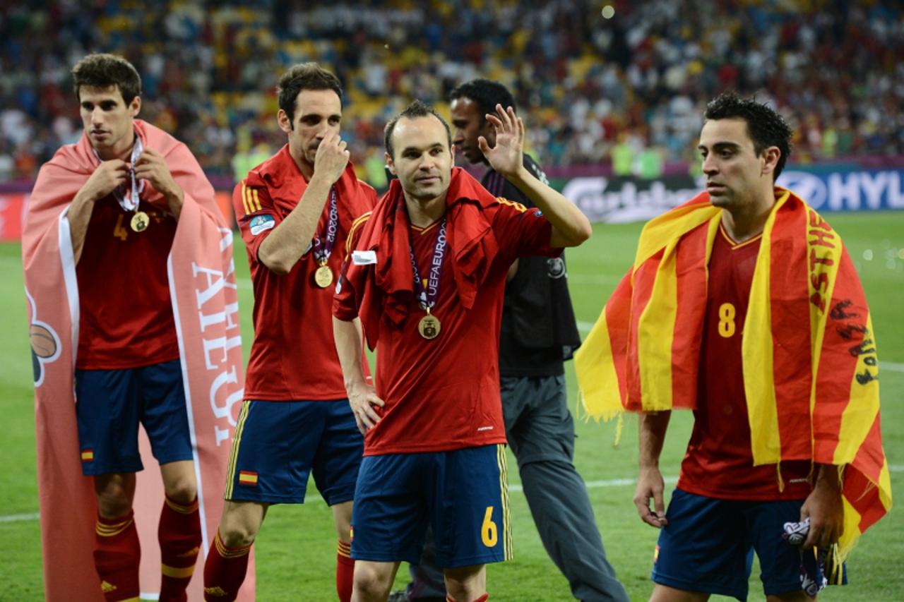 'Spanish players (From L) Javi Martinez, Juanfran, Andres Iniesta and Xavi Hernandez gestures after winning the Euro 2012 football championships final match Spain vs Italy on July 1, 2012 at the Olymp