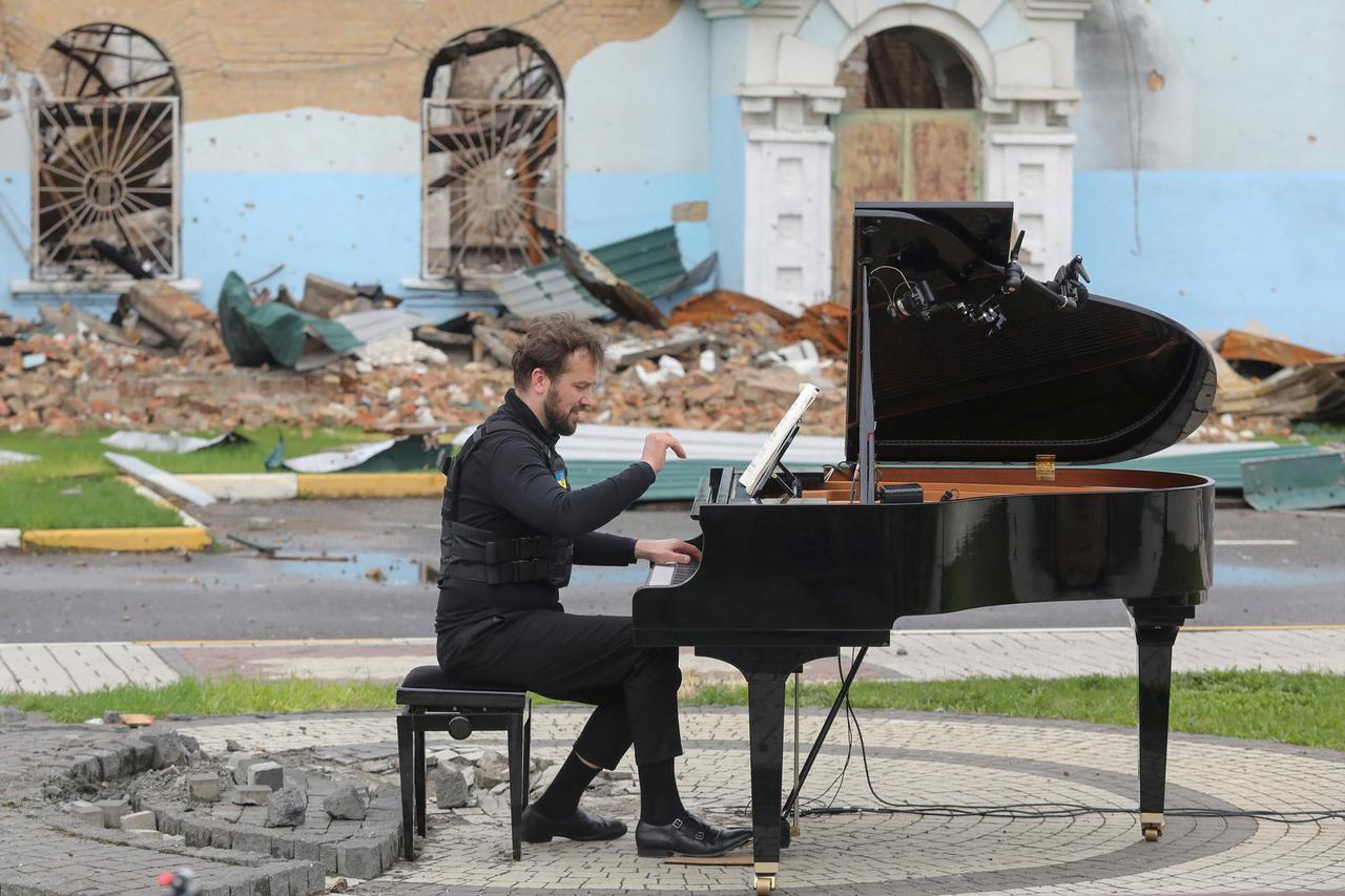 FILE PHOTO: Lithuanian musician Mazintas plays a piano in front of the destroyed Central House of Culture in Irpin
