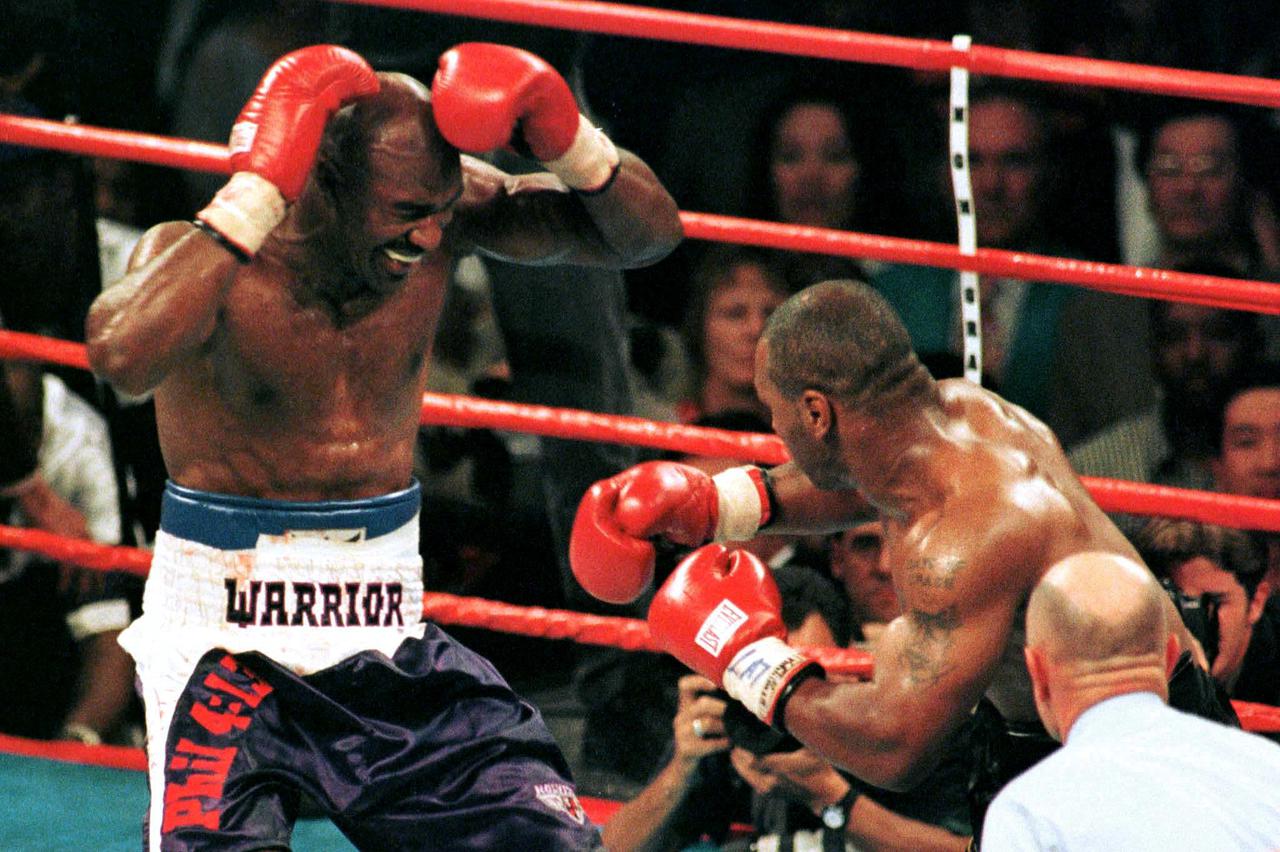 FILE PHOTO: Evander Holyfield (L) reacts after Mike Tyson (R) bit his ear during the third round of their WBA he..