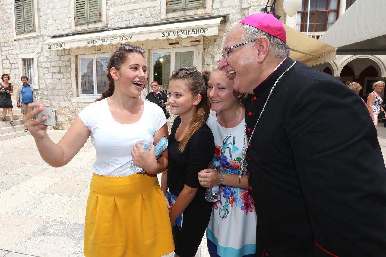 25.07.2016., Sibenik -  Nakon redjenja biskupa Tomislava Rogica djevojke su zamolile za selfie. Biskup je radosno pristao i poducio djevojcice uz salu da se to zove samoklik. Photo: Dusko Jaramaz/PIXSELL