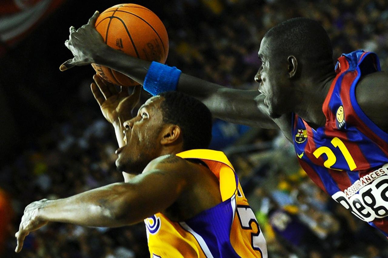 'Los Angeles Lakers\' Devin Ebanks (L) vies with Barcelona \\u0301s Boniface Ndong during a friendly match on October 7, 2010 at Palau Sant Jordi in Barcelona.     AFP PHOTO/ LLUIS GENE '