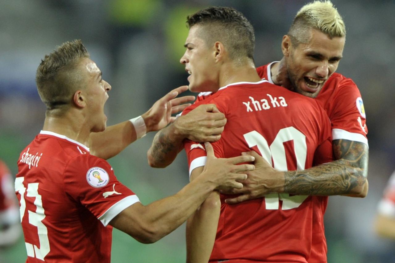 'Granit Xhaka of Switzerland (C) celebrates scoring a goal with team mates Xherdan Shaqiri (L) and Valon Behrami during their World Cup 2014 qualifying soccer match against Slovenia in Ljubljana, Sept