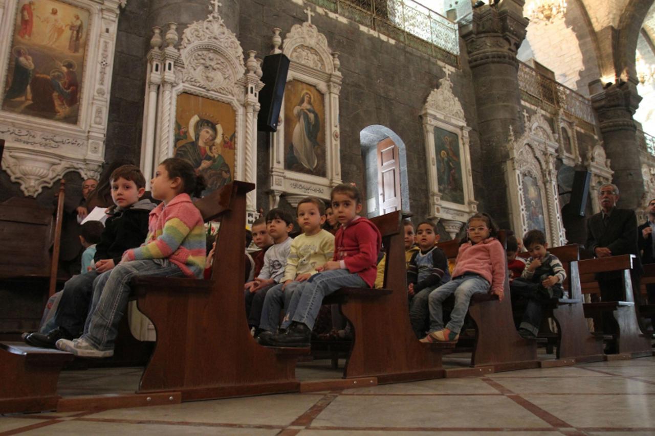 'Syrian Christian children attend Sunday mass at a church in Damascus on April 3, 2011. Syria\'s former agriculture minister Adel Safar was asked by President Bashar al-Assad to form a new government,