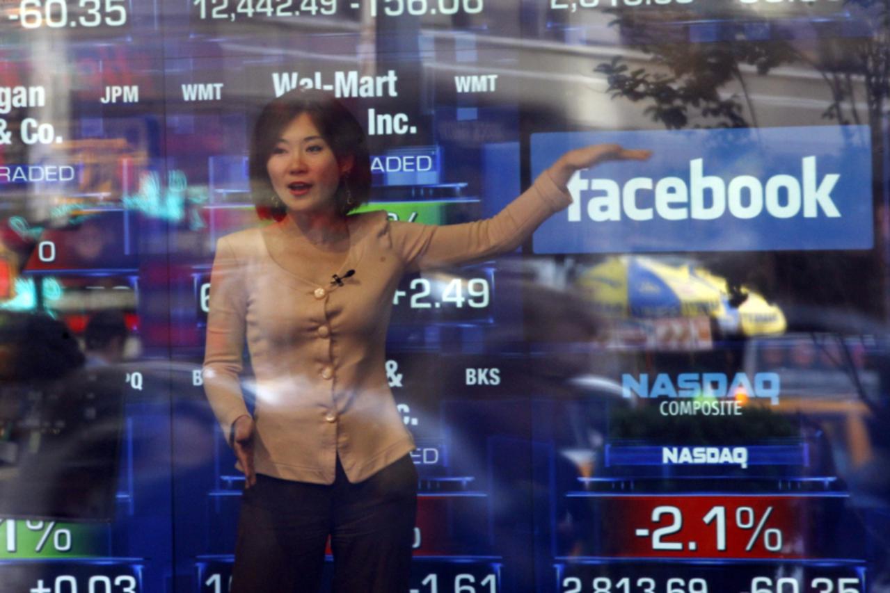 'A television reporter talks about the Facebook IPO at the NASDAQ Marketsite in New York May 17, 2012. Facebook Inc, will begin trading on the Nasdaq market on Friday, with its initial public offering