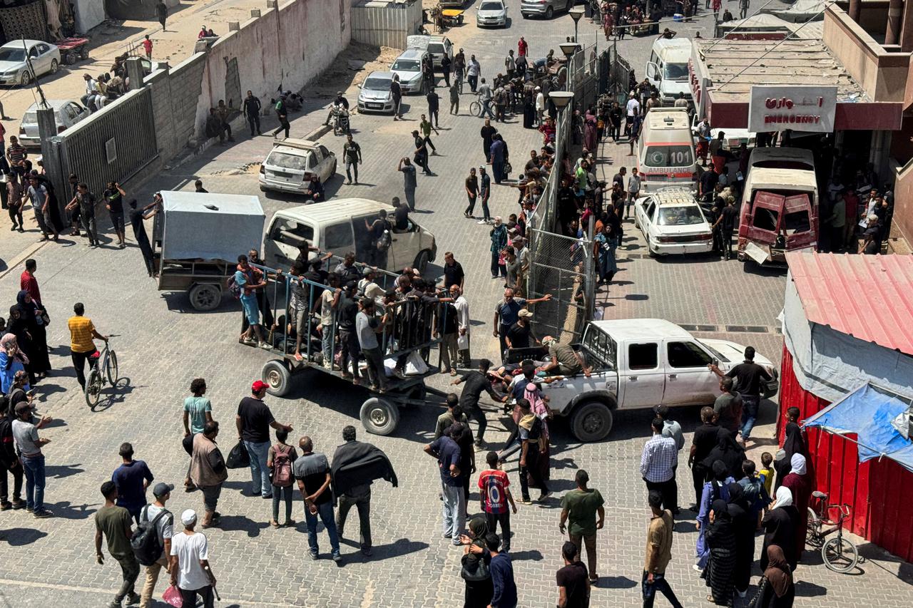 Palestinians carry casualties wounded by Israeli fire while waiting for aid, according to Gaza’s health ministry, in Khan Younis
