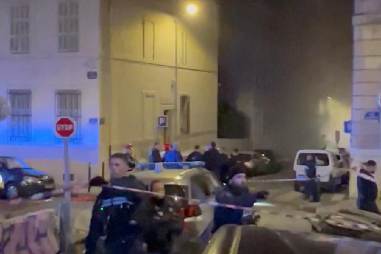 Smoke envelopes the area as police officers work at the scene of a fire following a gas explosion in Marseille