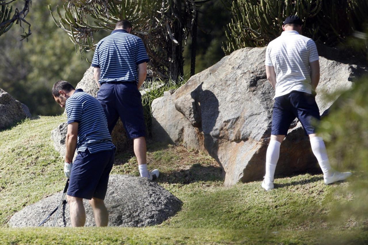 'England\'s striker Wayne Rooney (R) relieves himself while playing golf at the Lost City course of Sun City on June 13, 2010.  England\'s big names have rallied around under-fire Robert Green but ski