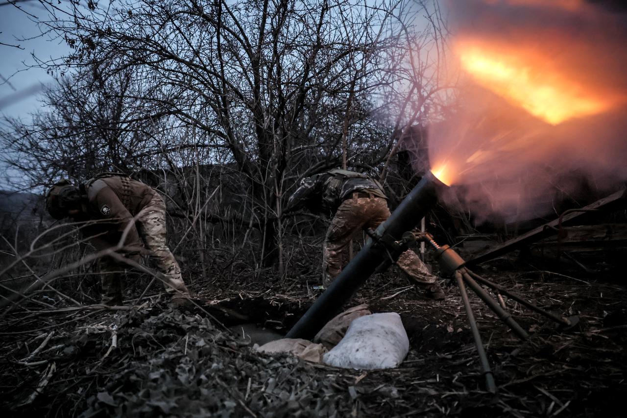 Ukrainian servicemen fire a 120-mm mortar towards Russian troops at a frontline near the town of Chasiv Yar