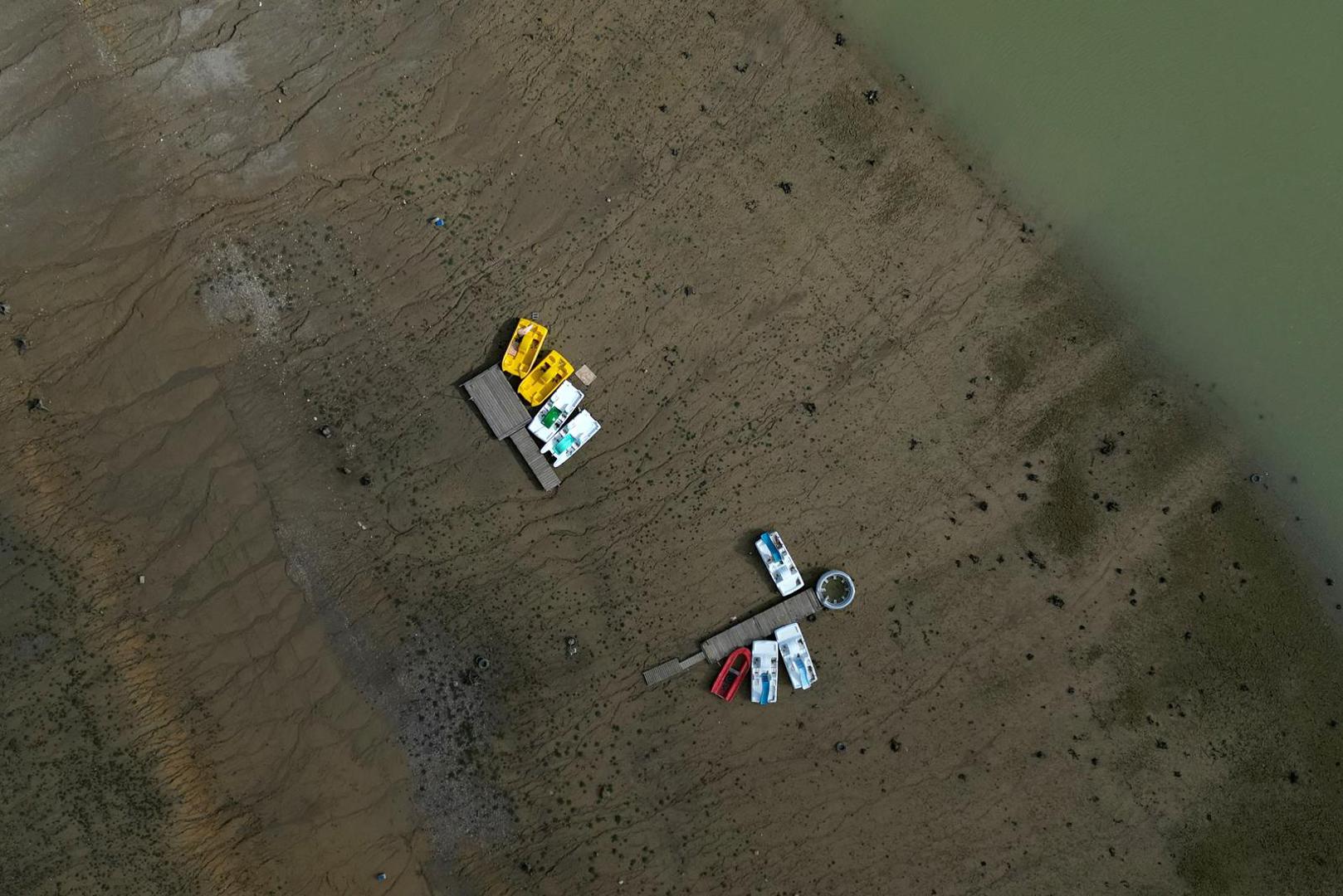 Boats are seen on the banks of the partially dry Lake Montbel at the foot of the Pyrenees Mountains as France faces records winter dry spell raising fears of another summer of droughts and water restrictions, March 15, 2023. REUTERS/Sarah Meyssonnier Photo: Sarah Meyssonnier/REUTERS