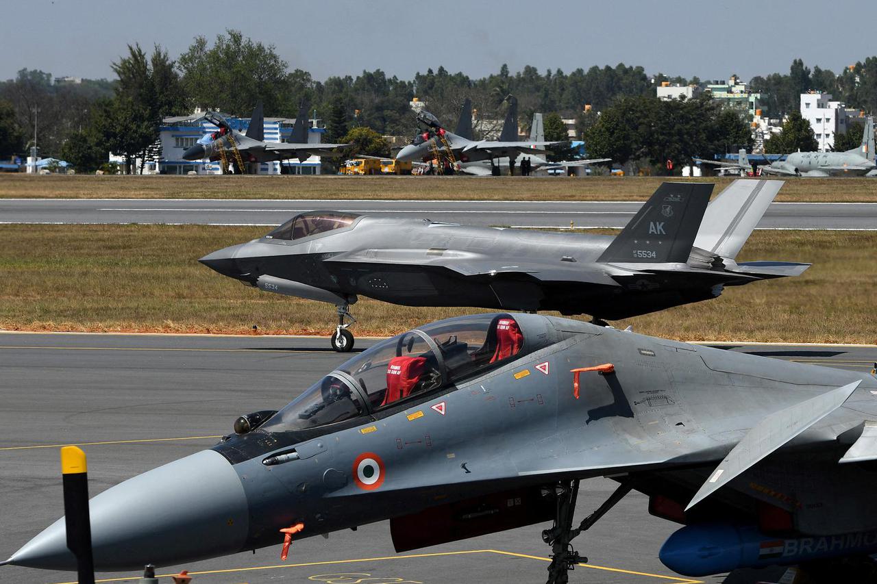 FILE PHOTO: A F-35 fighter jet moves past Indian Air Force's Sukhoi Su-30MKI fighter jet parked on tarmac during the "Aero India 2025" air show at Yelahanka air base in Bengaluru