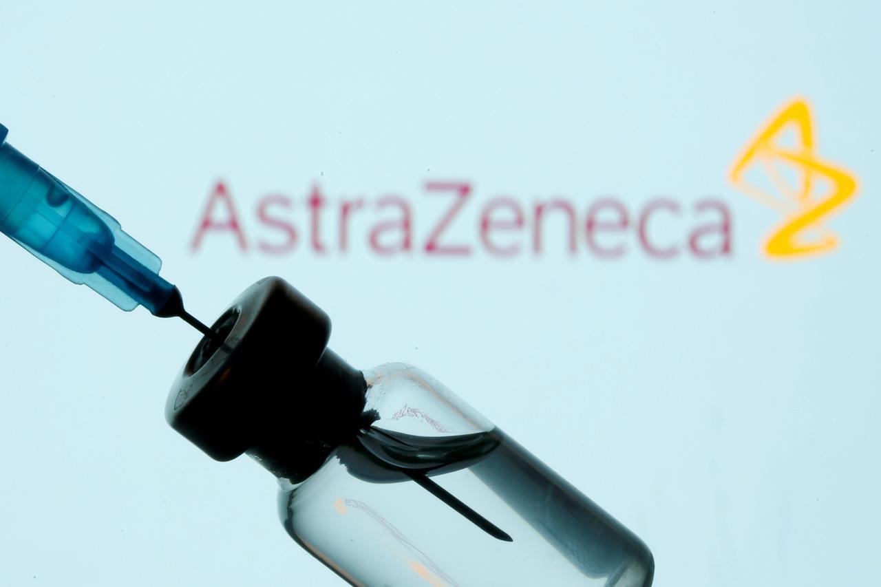 FILE PHOTO: Vial and sryinge are seen in front of displayed AstraZeneca logo