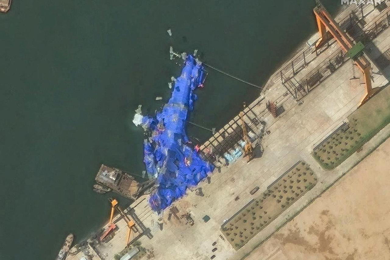 A satellite image shows a North Korean warship covered with a blue tarp after an accident that occurred during its launch at the shipyard in Chongjin