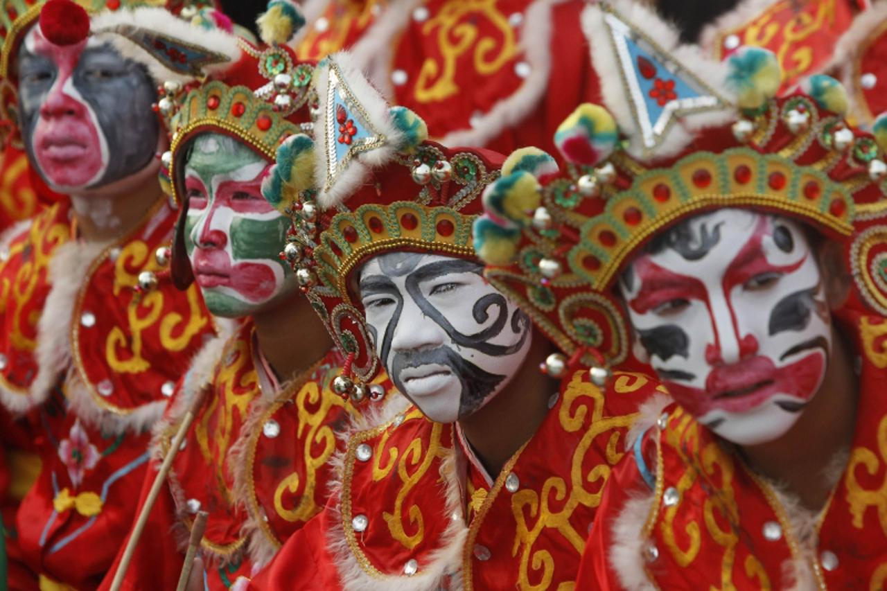 'Traditional Chinese dancers wait to perform ahead of the Chinese Lunar New Year celebrations in Suphan Buri province, about 65.2 miles (105 km) north of Bangkok February 8, 2013. The Lunar New Year, 