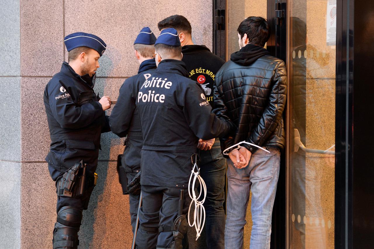 Police officers detain protesters during a protest against a visit of Turkey's President Recep Tayyip Erdogan, near Schuman square in Brussels
