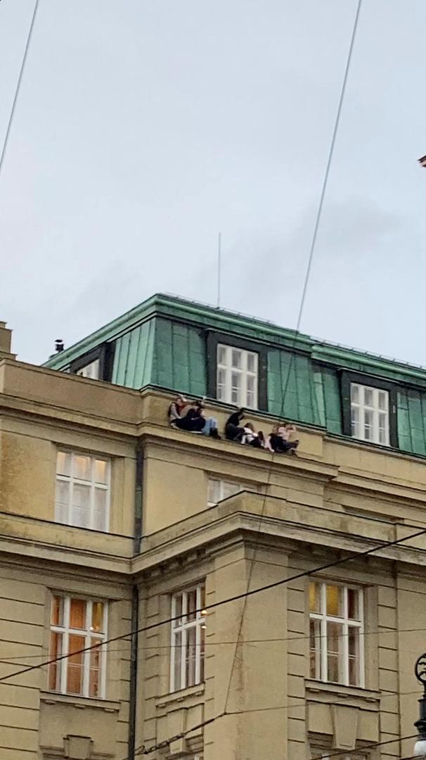 People watch from a roof following a shooting at one of the buildings of Charles University, in Prague, Czech Republic, December 21, 2023, as seen in this screen grab taken from a social media video. Ivo Havranek/via REUTERS  THIS IMAGE HAS BEEN SUPPLIED BY A THIRD PARTY. MANDATORY CREDIT. NO RESALES. NO ARCHIVES. Photo: IVO HAVRANEK/REUTERS