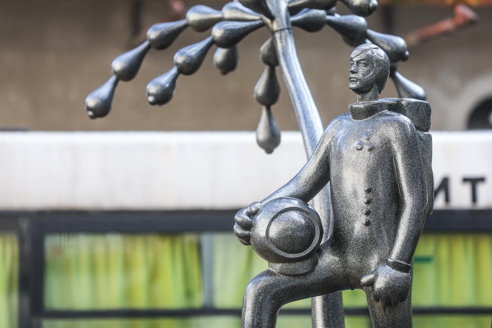 Riječ je o skulpturi-fontani kipara Ivana Fijolića koja je nagrađena na Trijenalu hrvatskoga kiparstva 2015. godine, a krije priču o svemiru i kiparstvu. Skulptura predstavlja pokojnog kipara Ratka Petrića, čiji je odlazak prikazan kao otkriće vode na Marsu, a simbol je bijega od svijeta i njegovih sputavanja. Polazište za djelo bila je Petrićeva skulptura "Lik u skafanderu". 