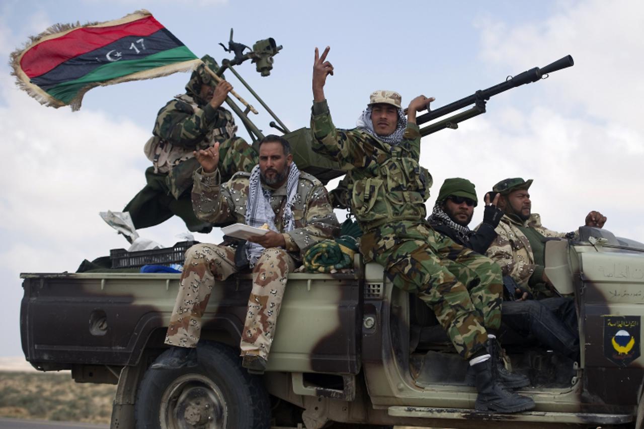 \'Libyan rebels head towards an area where they are engaged in street battles with forces loyal to Moamer Kadhafi near Brega on April 3, 2011. Rebels beat a fresh retreat from the key oil town after a