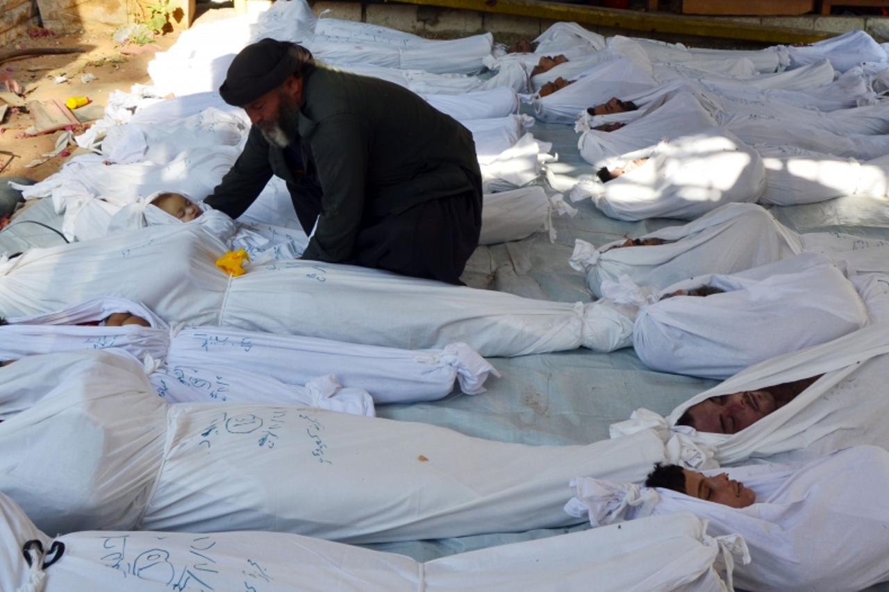 'ATTENTION EDITORS - VISUALS COVERAGE OF SCENES OF DEATH AND INJURY  A man holds the body of a dead child among bodies of people activists say were killed by nerve gas in the Ghouta region, in the Dum