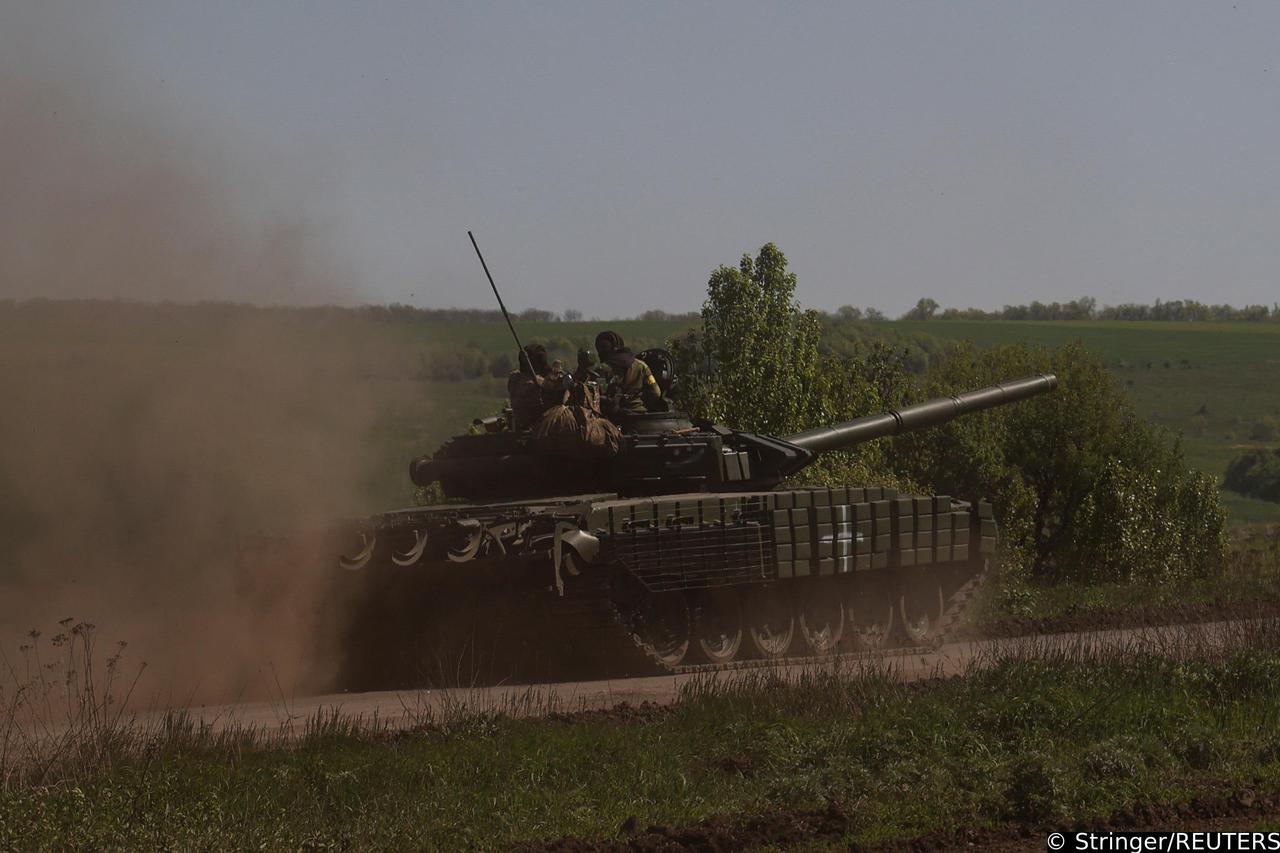 Ukrainian servicemen ride atop of a tank on a road to the frontline town of Bakhmut