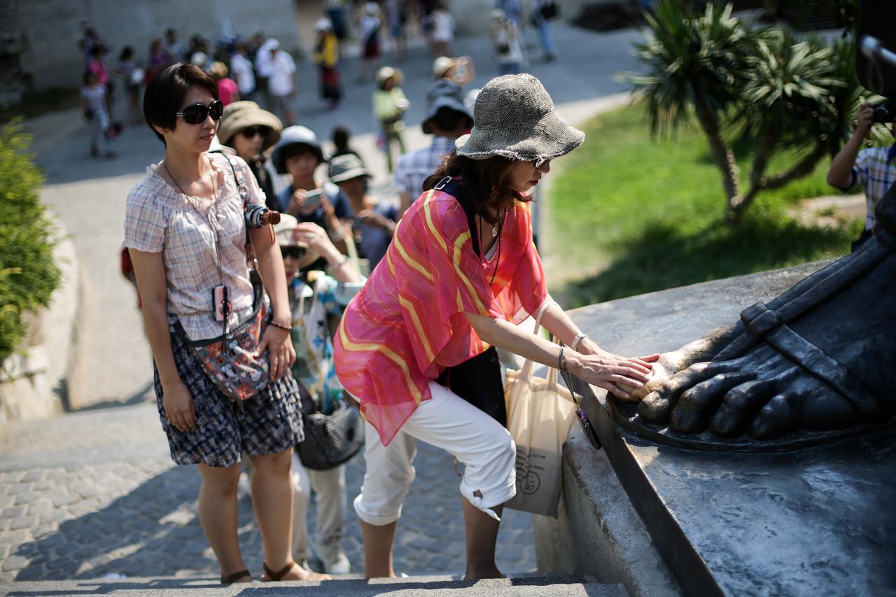 21.07.2015., Split - Stari i mladi cekaju u redu kako bi dotakli palac Grgura Ninskog i zazeljeli zelju.  Photo: Petar Glebov/PIXSELL