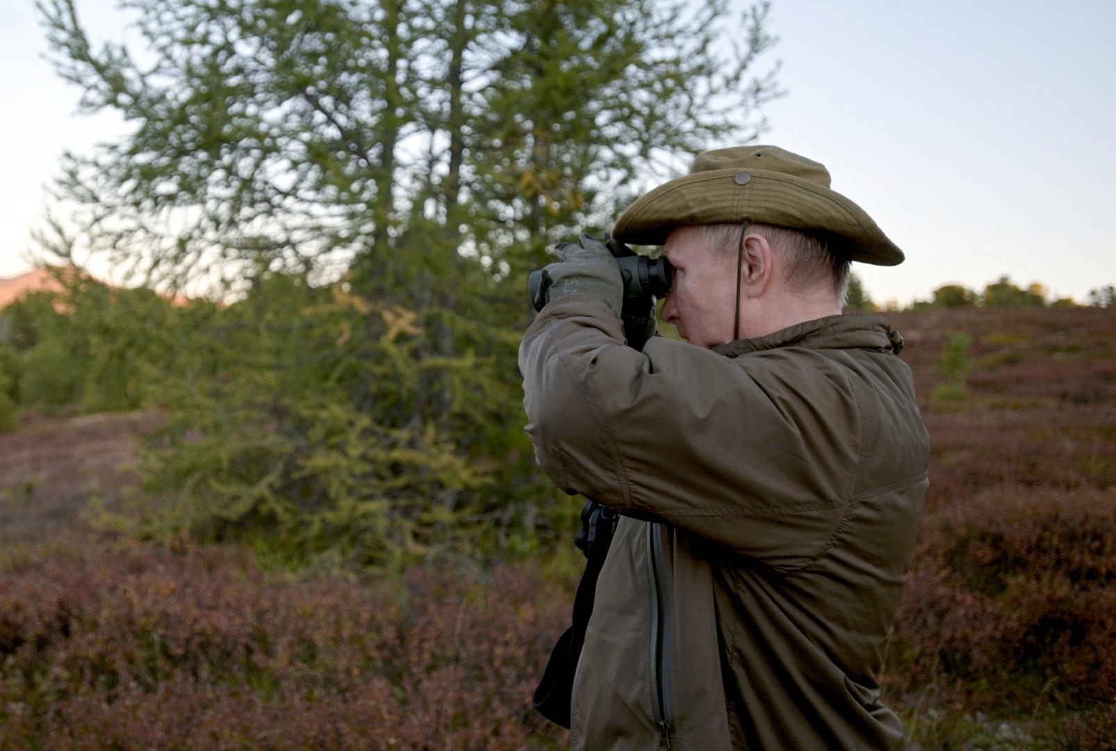 Russian President Vladimir Putin spends vacations in Siberia Russian President Vladimir Putin looks through binoculars during a short vacation at an unknown location in Siberia, Russia, in this undated photo taken in September 2021 and released September 26, 2021. Sputnik/Alexei Druzhinin/Kremlin via REUTERS  ATTENTION EDITORS - THIS IMAGE WAS PROVIDED BY A THIRD PARTY. SPUTNIK