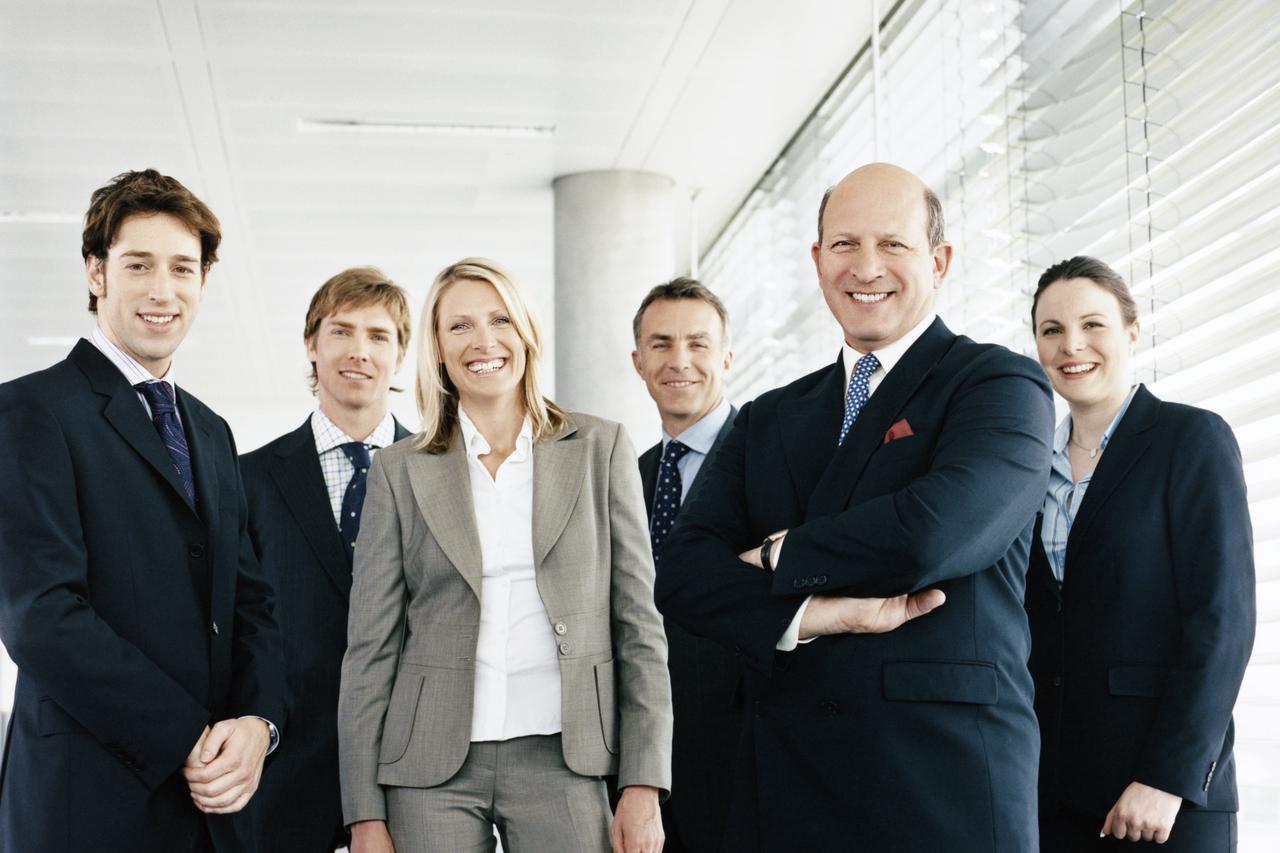 Portrait of a CEO With His Team of Business Executives Standing by a Window