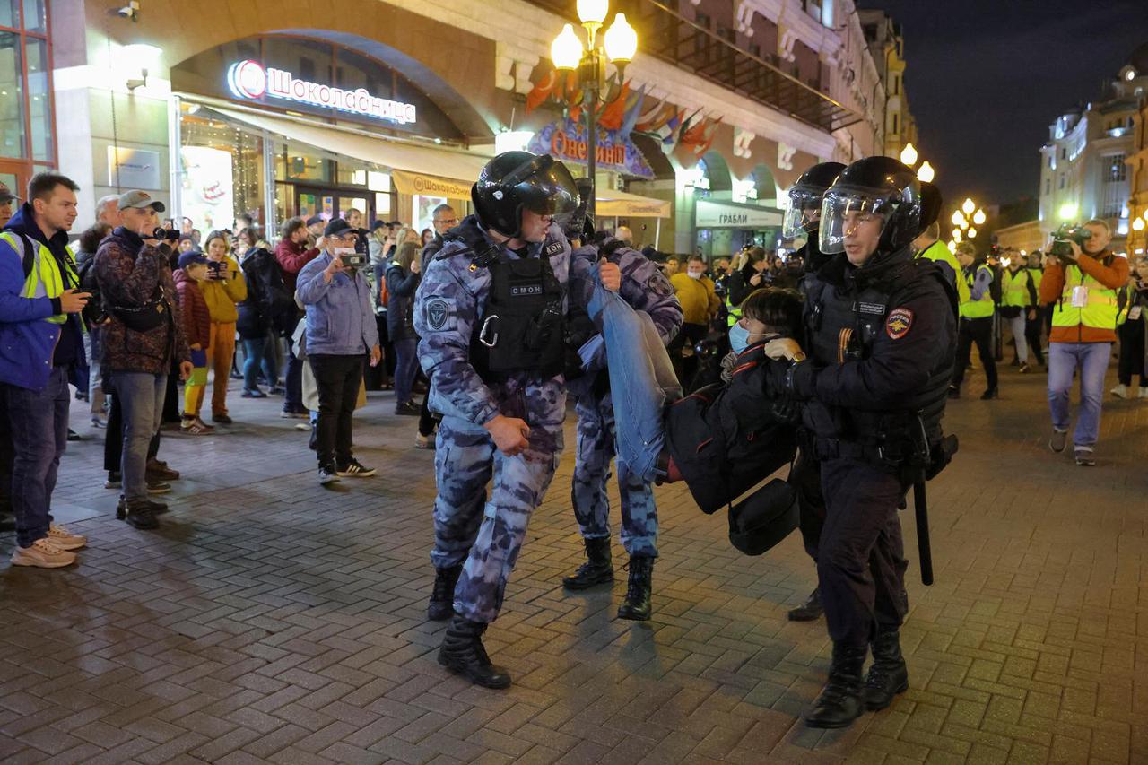 Russian police officers detain a person during an unsanctioned rally in Moscow