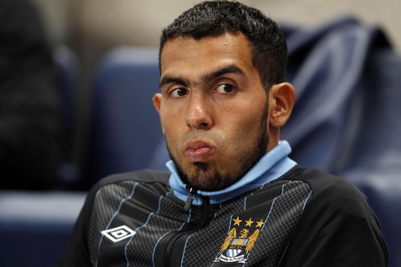 'Manchester City's Carlos Tevez sits on the bench before their Champions League Group A soccer match against Napoli at the Etihad Stadium in Manchester, northern England in this September 14, 2011 fi