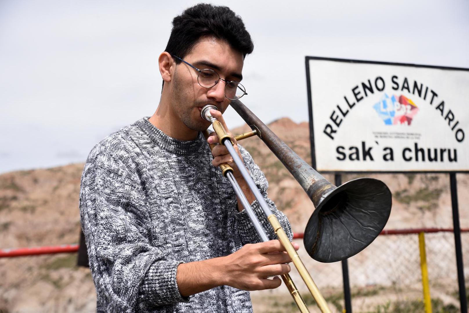 A musician from Paraguay's Orchestra of Recycled Instruments of Cateura, plays a trumpet made with recycled materials at the viewpoint of the Sak'a Churu landfill in Alpacoma, in La Paz, Bolivia February 27, 2023. REUTERS/Claudia Morales Photo: CLAUDIA MORALES/REUTERS