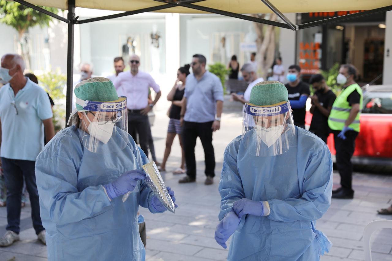 Medical health workers in a Personal Protective Equipment (PPE) are seen during a voluntary coronavirus disease (COVID-19) test in Limassol