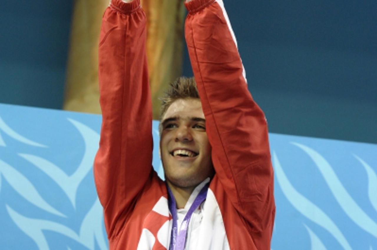 'Ivan Capan of Croatia celebrates his gold medal in the youth men\'s 50m breaststroke on day 6 of swimming at the Singapore 2010 Youth Olympic Games (YOG) at the Singapore Sports School, Aug 20, 2010.