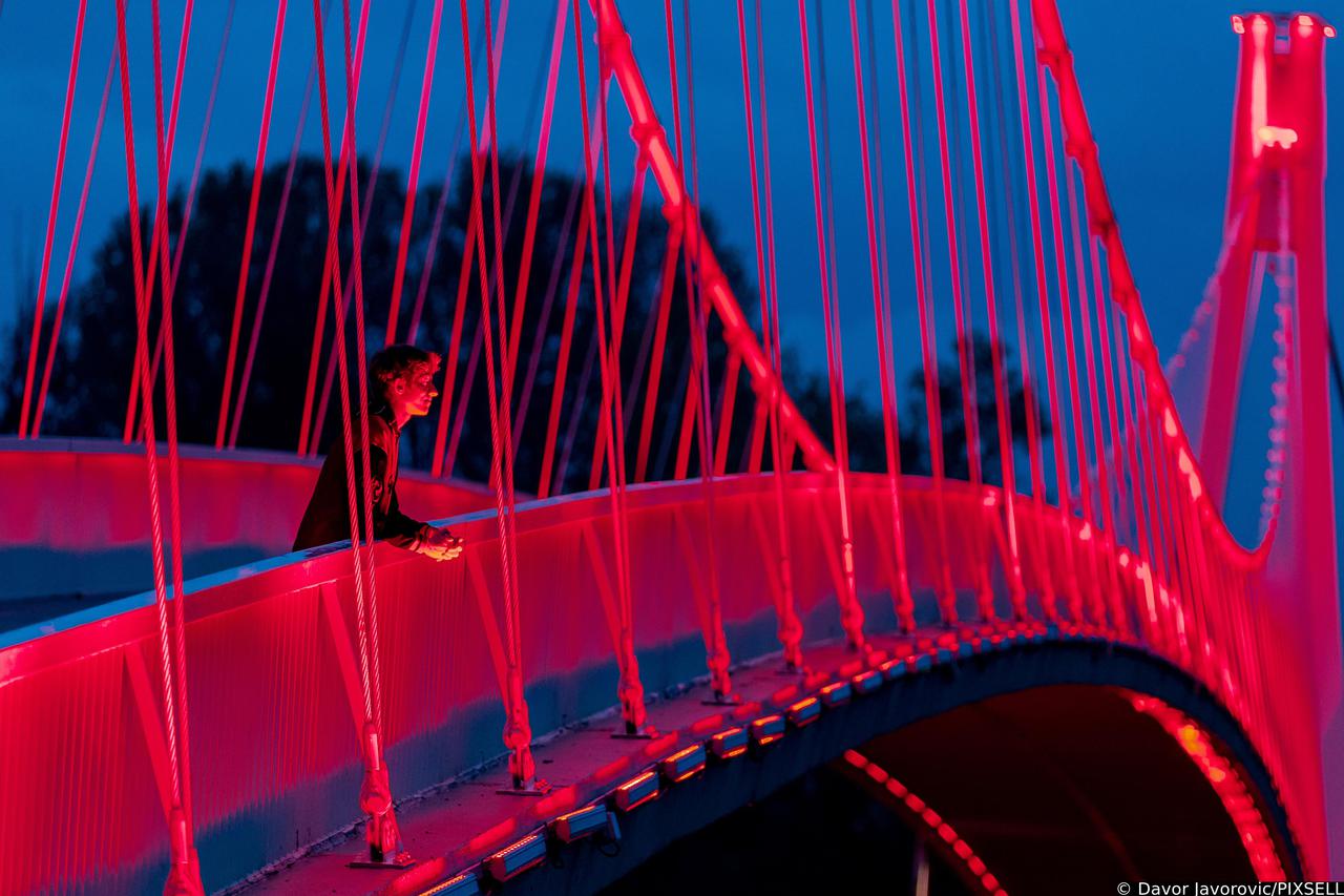 Pješački most preko rijeke Drave u Osijeku osvijetljen crvenom bojom