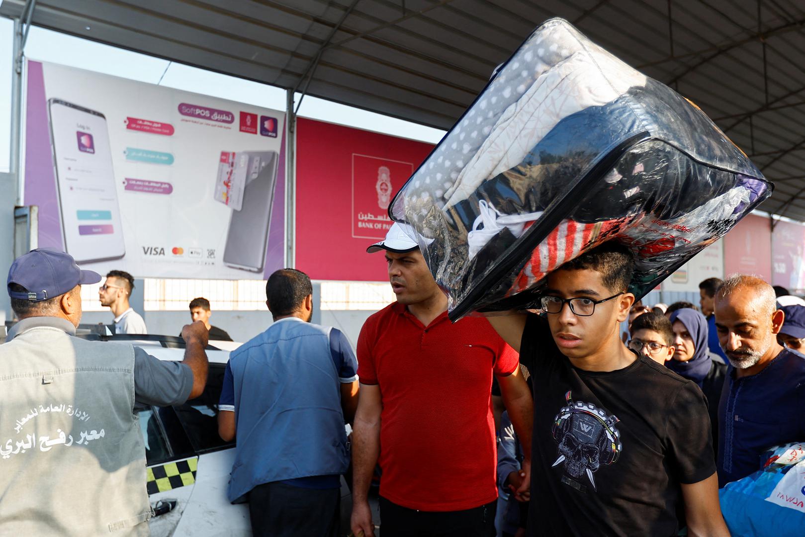 A man carries a piece of luggage as Palestinians with dual citizenship wait for permission to leave Gaza, amid the ongoing conflict between Israel and Palestinian Islamist group Hamas, at the Rafah border crossing with Egypt, in Rafah in the southern Gaza Strip, November 2, 2023. REUTERS/Ibraheem Abu Mustafa Photo: IBRAHEEM ABU MUSTAFA/REUTERS