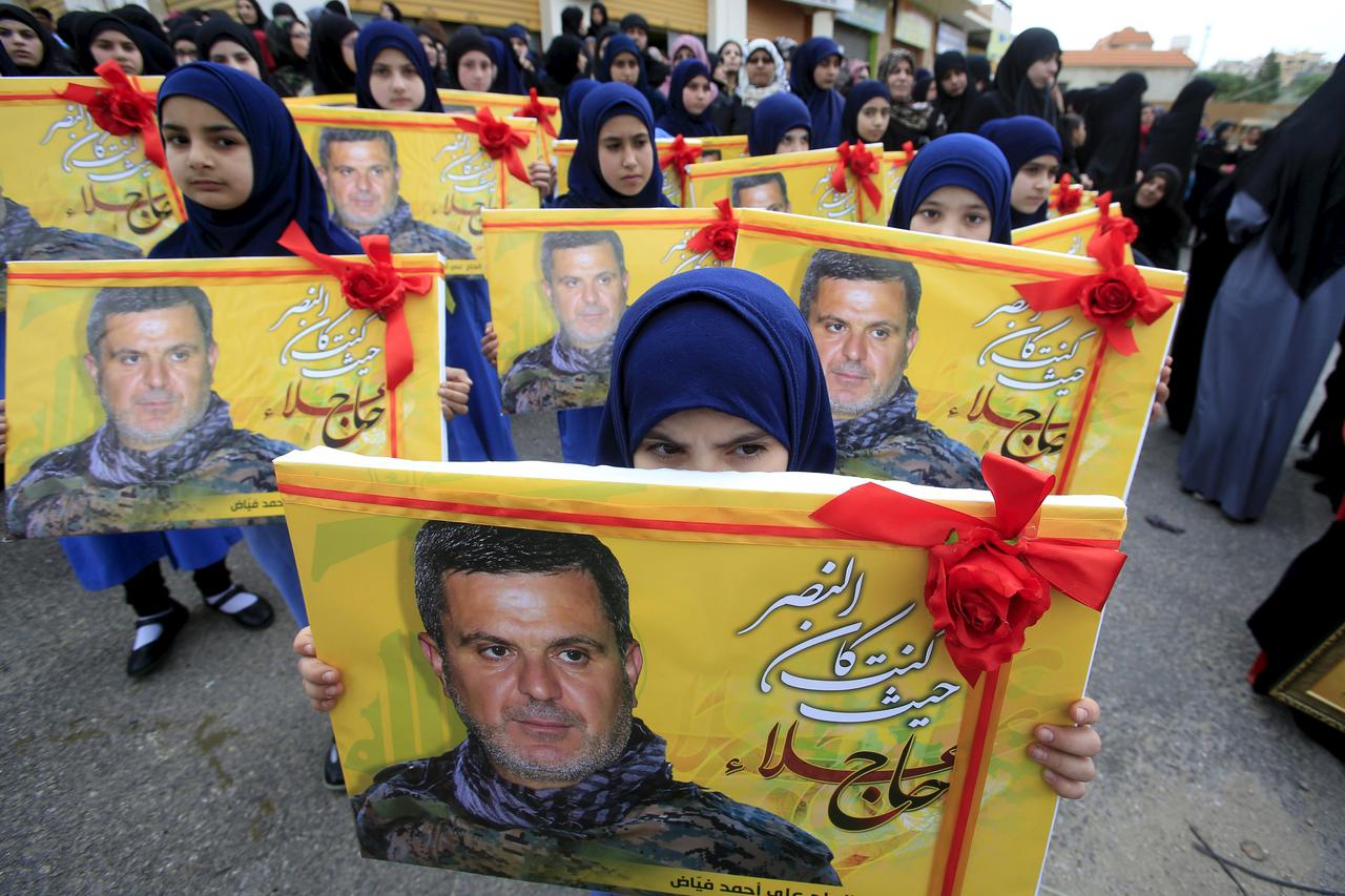Lebanon's Hezbollah al-Mahdi girl scouts carry pictures of Ali Fayyad, one of Hezbollah's senior commanders who was killed fighting alongside Syrian army forces in Syria, during his funeral in Ansar village, southern Lebanon March 2, 2016. REUTERS/Ali Has