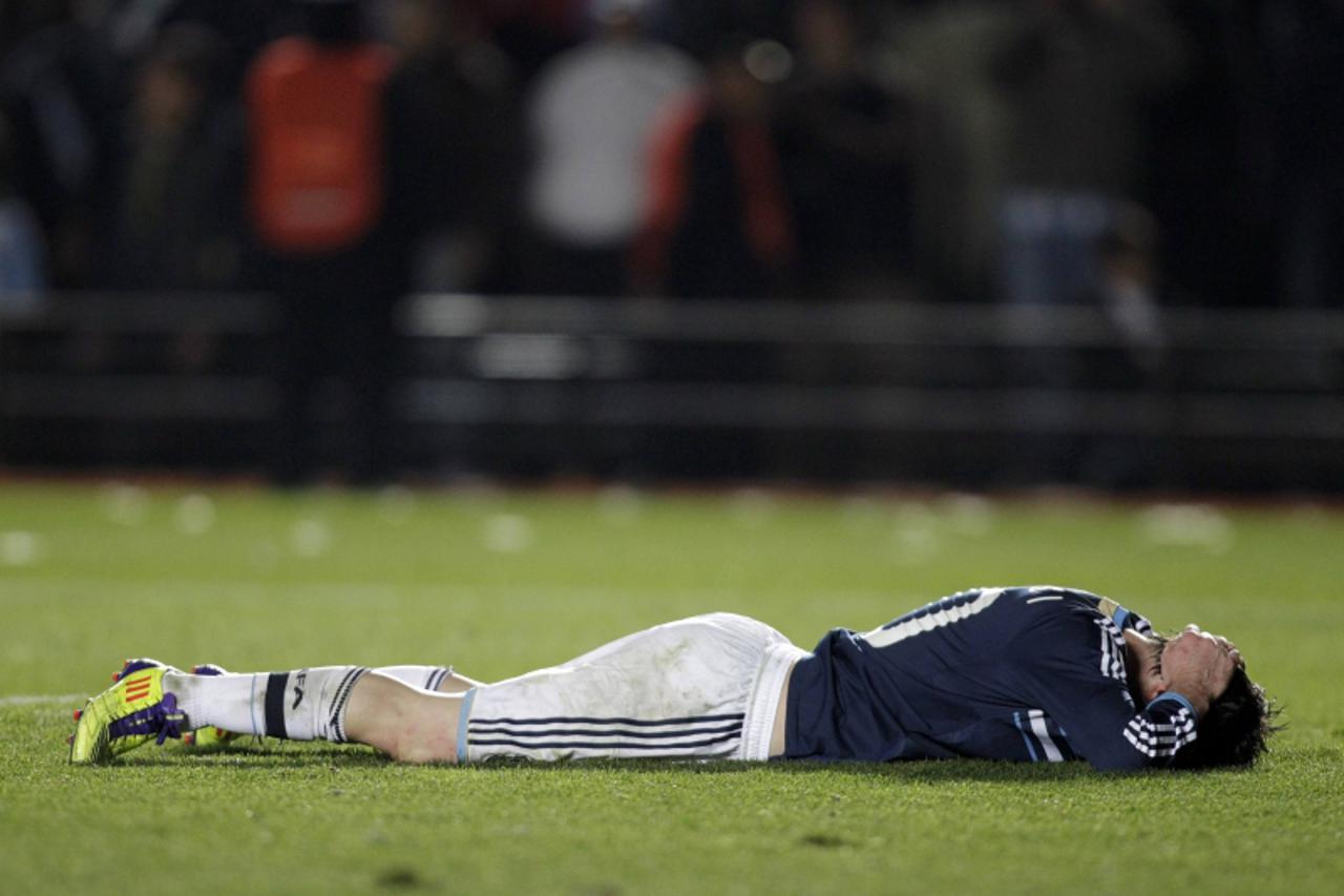 'Argentina\'s Lionel Messi lies on the ground after missing a goal opportunity against Uruguay in their quarter-final soccer match at the Copa America in Santa Fe, July 16, 2011.            REUTERS/Da