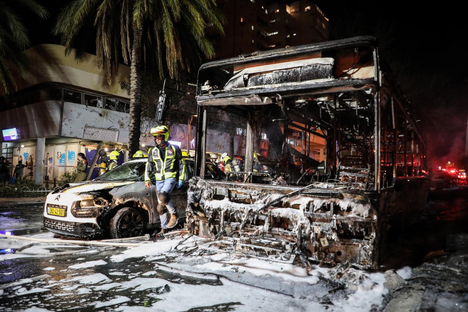 11 May 2021, Israel, Holon: Israeli firefighters work around a burnt bus, after it was hit by a rocket fired by the Palestinian Islamist movement Hamas from Gaza towards Israel amid the escalating flare-up of Israeli-Palestinian violence. Photo: Oren Ziv/dpa /DPA/PIXSELL