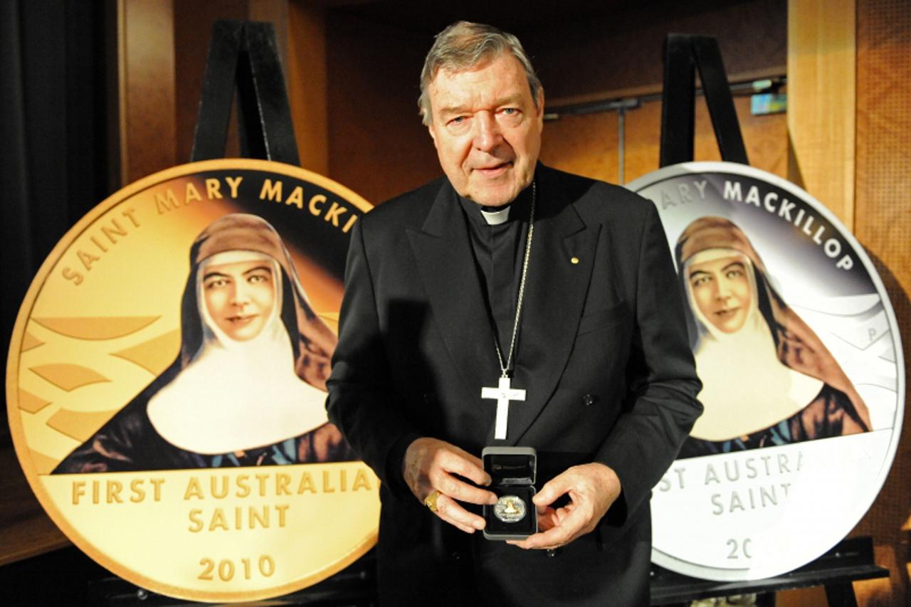 'Cardinal George Pell, Catholic Archbishop of Sydney, unveils Australia\'s first pure gold (L) and silver (R) coins commemorating the canonisation of Mary MacKillop in Sydney on September 30, 2010. Ma