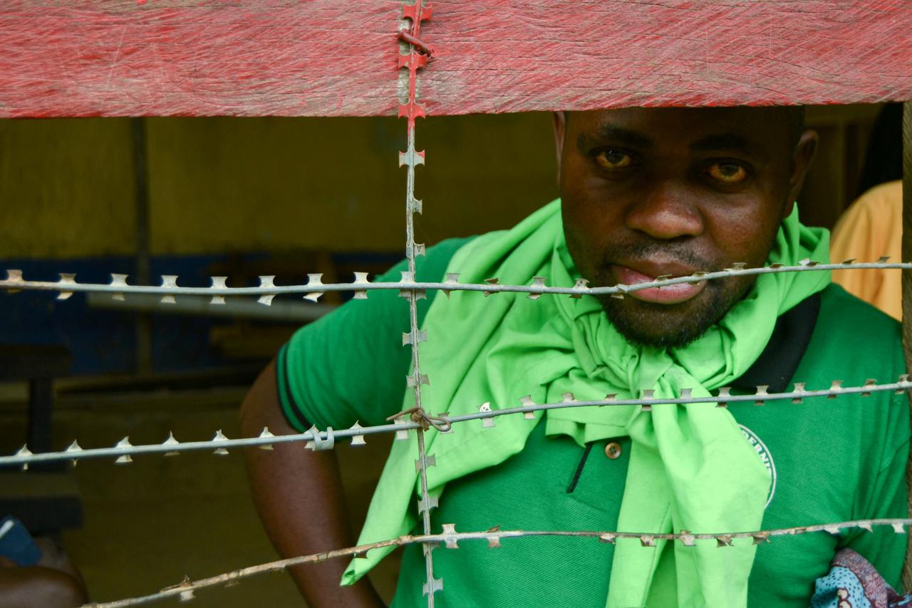 Stephane Kambale, a Congolese inmate is seen through the secure wire fence inside the Central de Bunia prison in the northeast of town Bunia