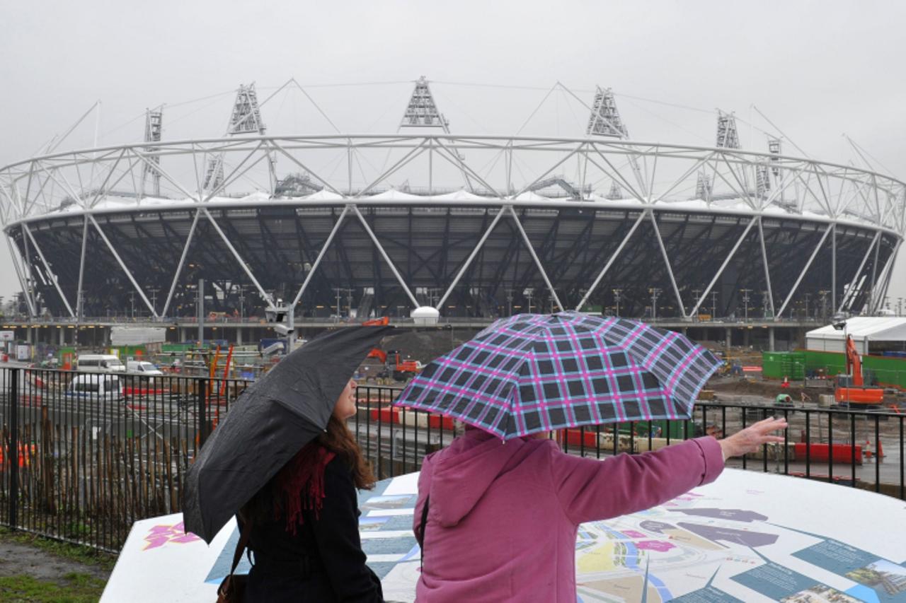 \'Tourists looks towards the 2012 Olympics stadium in London February 10, 2011. Britain\'s Olympic Park Legacy Company (OPLC) is expected on Friday to announce whether West Ham United or rival bidders