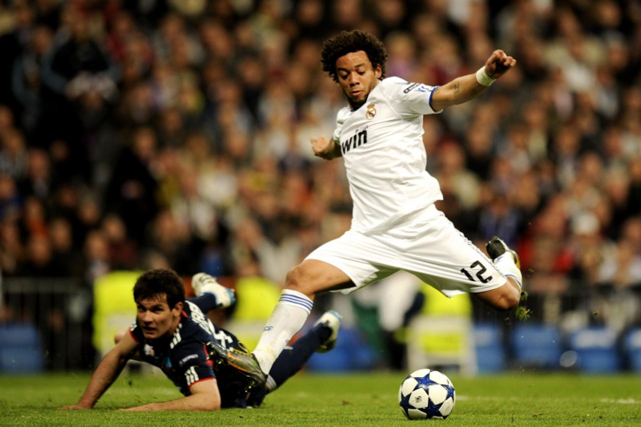 \'Real Madrid\'s Brazilian defender Marcelo (R) vies with Olympique Lyonnais\' Croatian defender Dejan Lovren (R) during their Champions League match at the Santiago Bernabeu Stadiun in Madrid on Marc