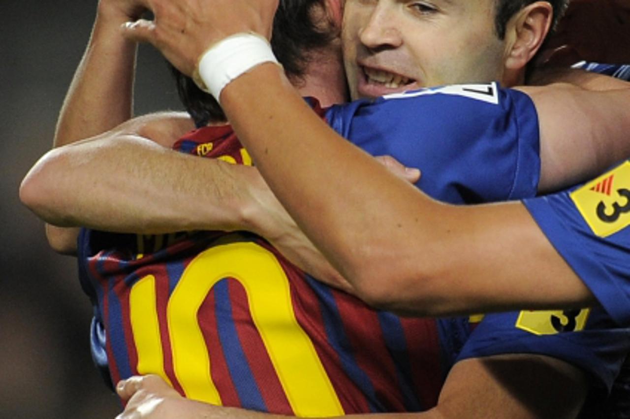 'Barcelona\'s Argentinian forward Lionel Messi (L) celebrates with teammate Barcelona\'s midfielder Andres Iniesta (R) after scoring during the Spanish league football match FC Barcelona vs Getafe CF 
