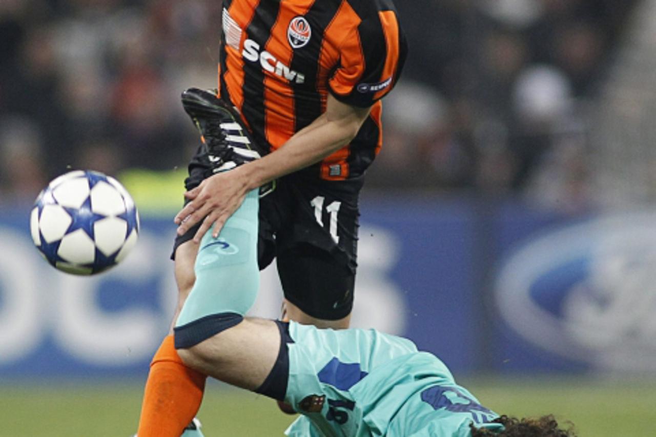 'Shakhtar Donetsk\'s Eduardo (L) fights for the ball with Barcelona\'s Gabriel Milito during the second leg of their Champions League quarter-final soccer match at the Donbass Arena in Donetsk April 1