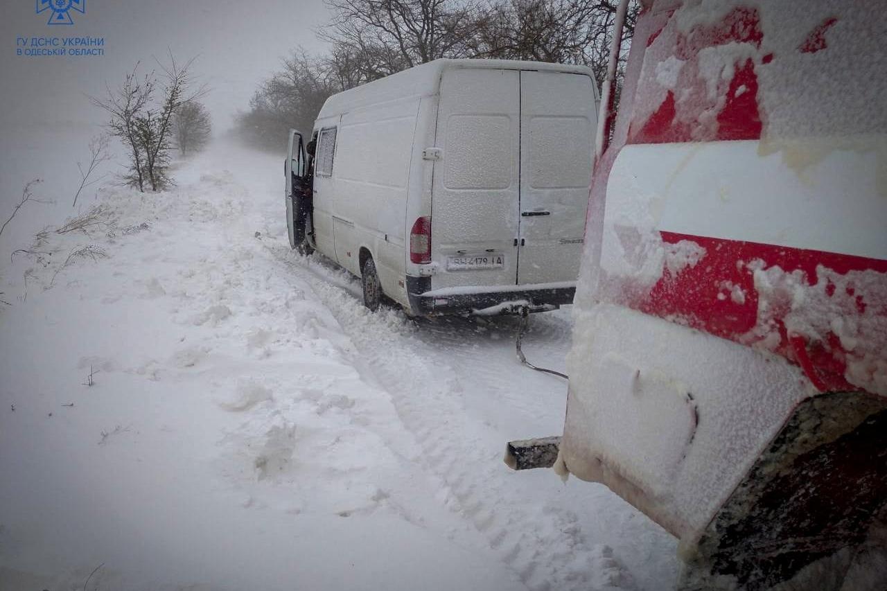 Emergency workers release a van which is stuck in snow during a heavy snow storm in Odesa region