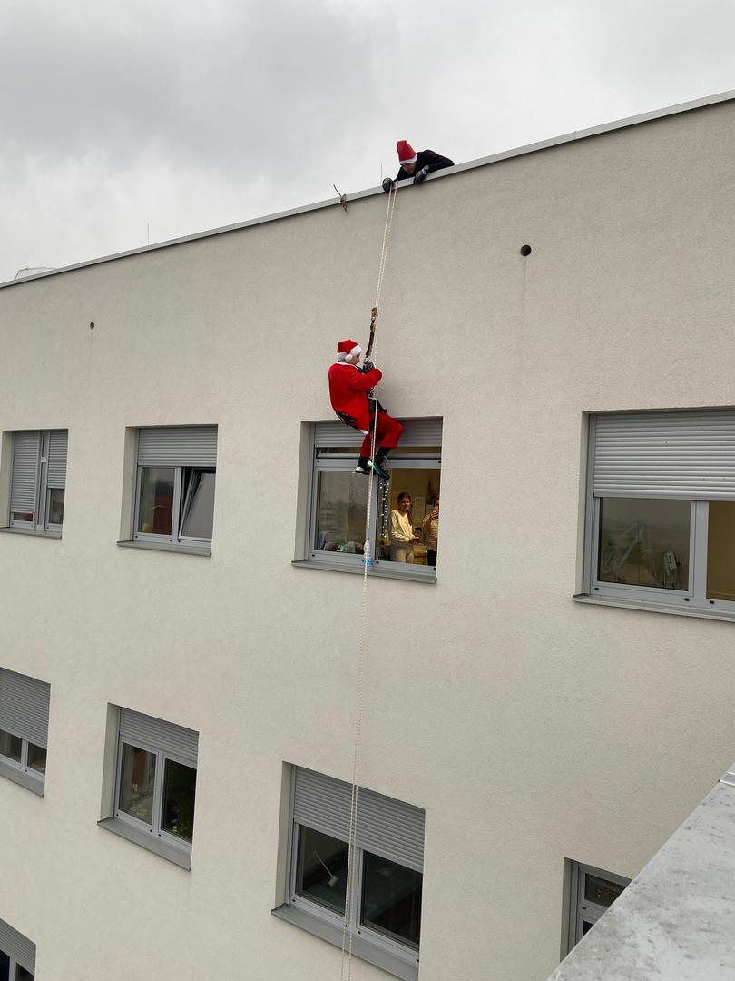Djedovi Mrazovi spuštali su se niz pročelja bolničkih zgrada i kroz prozore darivali male pacijente, izmamivši im osmijehe i oduševljenje