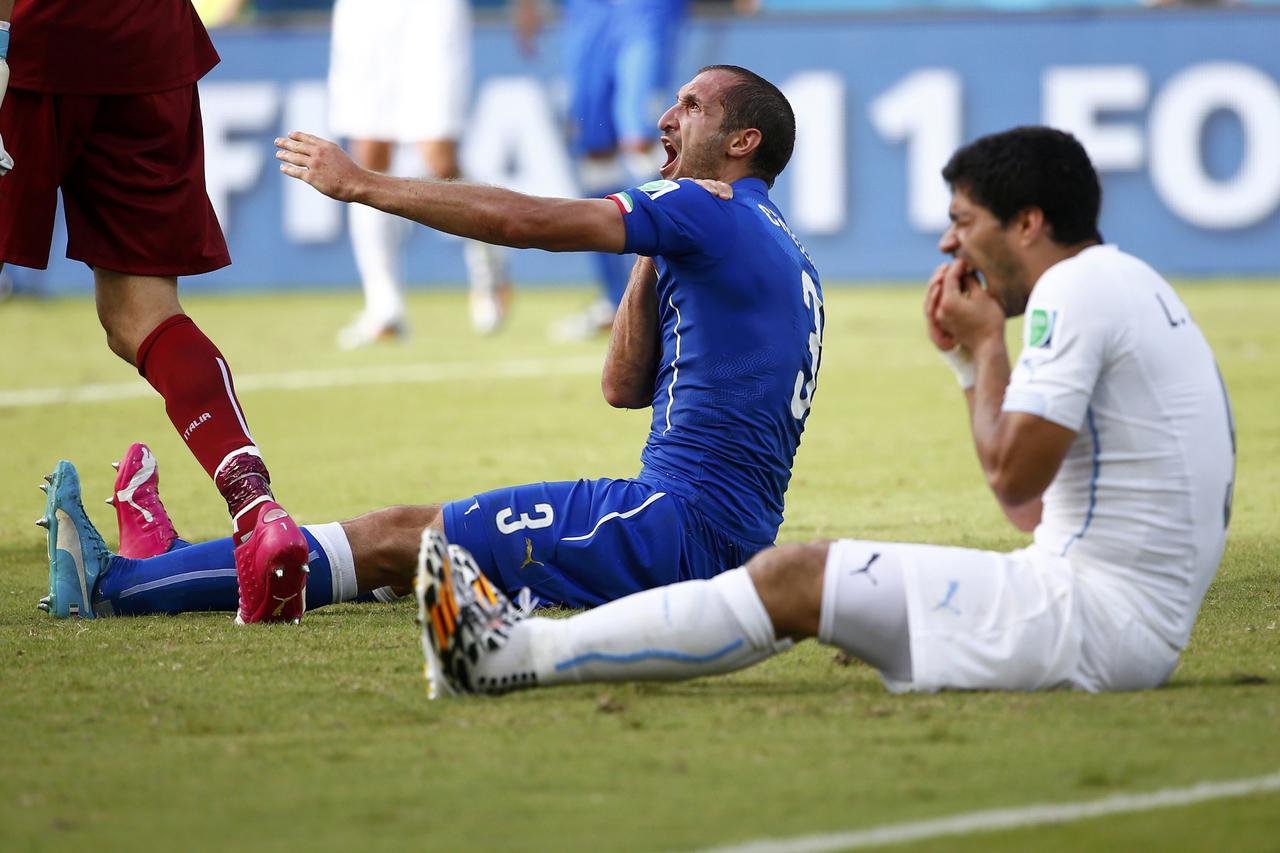 Uruguay's Luis Suarez (R) reacts after clashing with Italy's Giorgio Chiellini during their 2014 World Cup Group D soccer match at the Dunas arena in Natal in this June 24, 2014 file photograph. Uruguay striker Suarez was banned for nine matches by FIFA o
