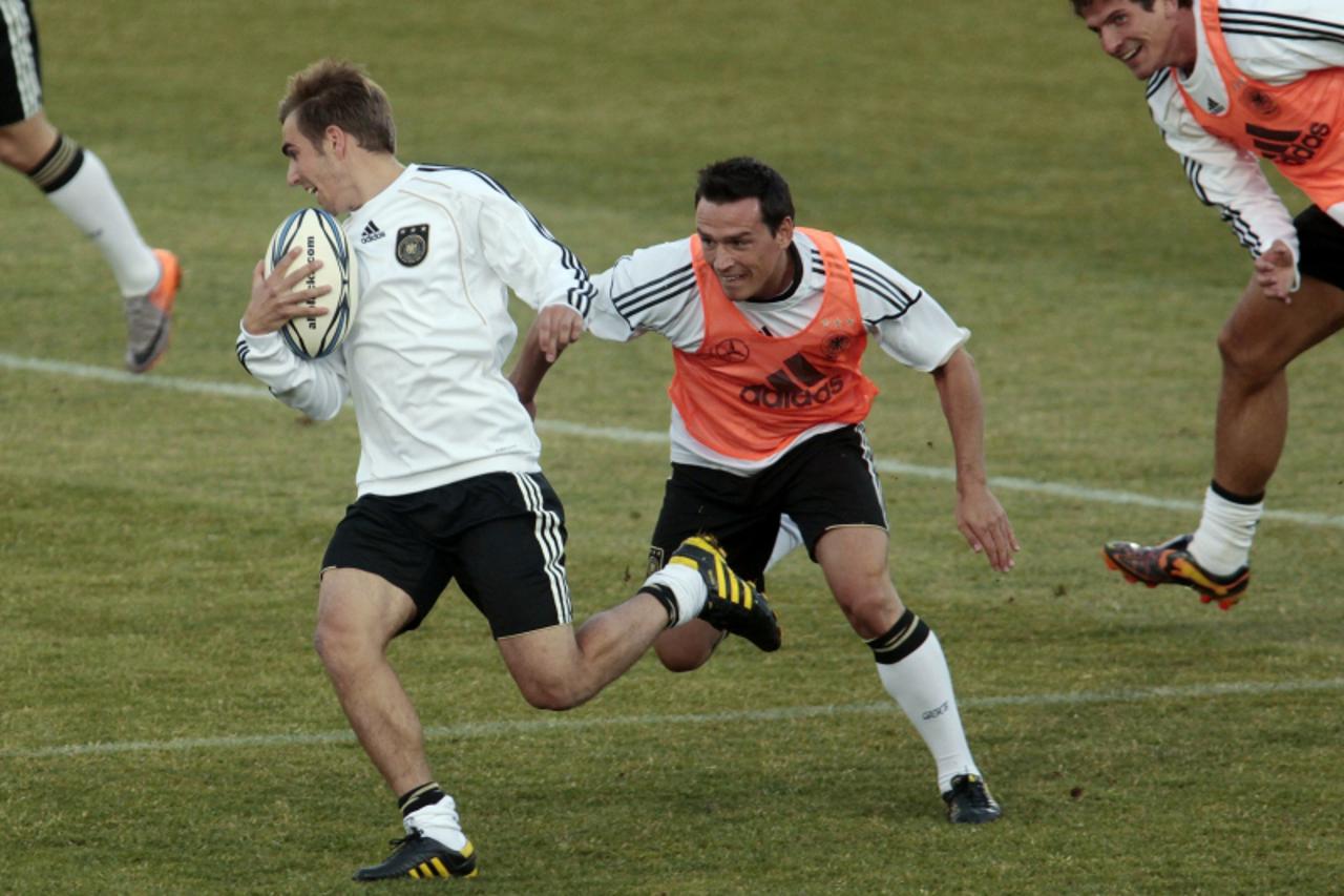 'Germany\'s Philipp Lahm and Piotr Trochowski (R) play rugby during a training session in Pretoria June 21, 2010.  REUTERS/Ina Fassbender (SOUTH AFRICA - Tags: SPORT SOCCER WORLD CUP)'